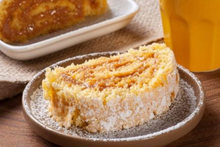 rocambole de churros com doce de leite e coco em um prato redondo