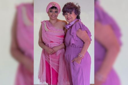 Imagem colorida de mãe e filha vestidas de rosa abaraçdas para a foto - Metrópoles