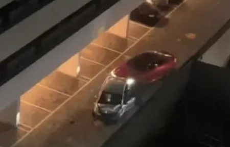 Imagem colorida mostra um carro vermelho, de MC Paiva, arrastando um carro prata dentro de um estacionamento em São José dos Campos, interior de São Paulo - Metrópoles