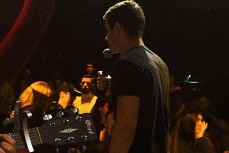 Foto colorida de culto no Galpão, com o influencer Victor Bonato, líder do movimento evangélico, pregando ao microfone - Metrópoles
