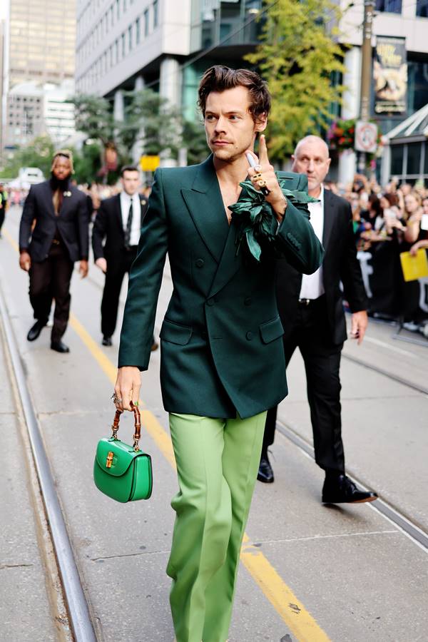 Harry Styles está entre os homens que usam bolsas Na rua, o cantor Harry Styles usa look todo verde de alfaiataria com bolsa de mão que tem alça de bambu - Metrópoles