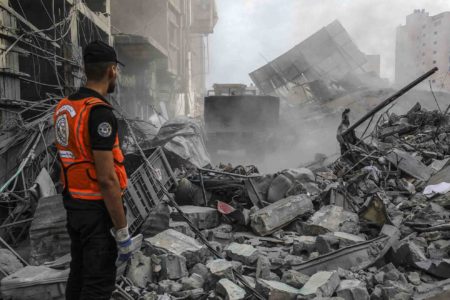 Palestinos procuram nos escombros vítimas em um prédio após ataques aéreos israelenses em Khan Yunis, Gaza - Metrópoles