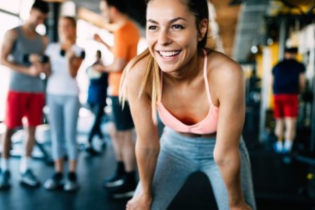 mulher treinando em academia loira de top rosa - treino regenerativo