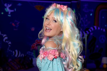 foto colorida de xuxa com vestido azul com aplicações de flores e detalhes azuis em cabelo, com tiara de flores - metrópoles