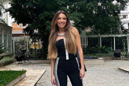 Foto colorida de uma mulher de cabelos longos com cabelo grande e roupa preta -Metrópoles