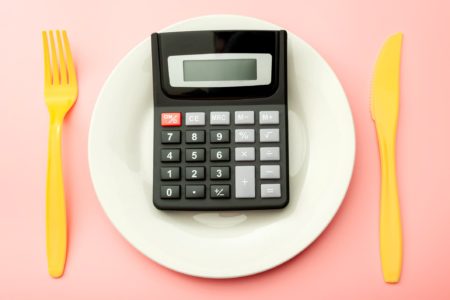 Foto mostra calculadora colocada sobre um prato representando a quantidade de calorias - Metrópoles