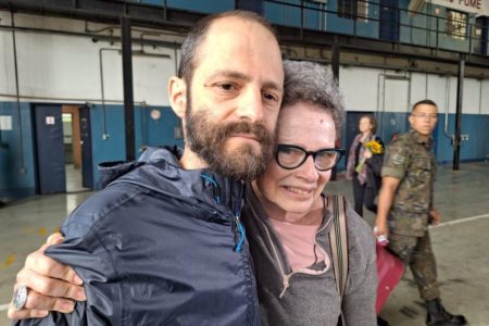 Foto colorida da aposentada Evelyn Crimerman e do filho Tiago Marchesano na base aérea de São Paulo, em Guarulhos, após retorno dela de Israel - Metrópoles