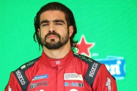 Foto colorida de Caio Castro usando macacão de corrida - Metrópoles