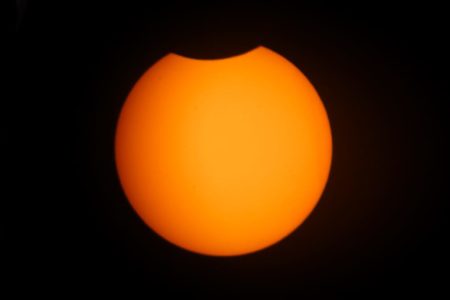 imagem colorida. Sol começando a ser encoberto pela Lua