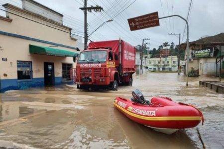 Foto colorida de caminhão e bote dos Bombeiros em rua alagada pela chuva - Metrópoles