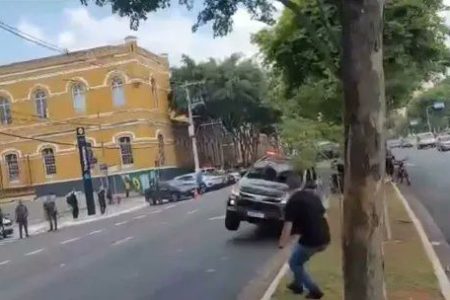 Imagem colorida mostra viatura da Rota com apenas duas rodas, as do lado esquerdo do veículo, no asfalto, durante manobra que derrubou um poste e acertou uma moto no centro de São Paulo - Metrópoles