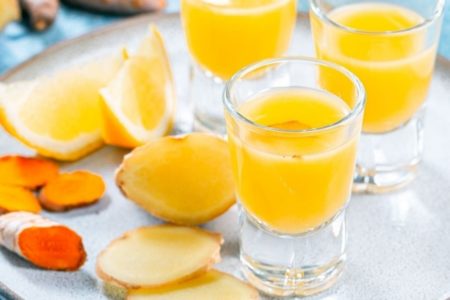 Suco de laranja com algumas cortadas sobre a mesa