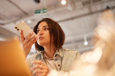 Foto mostra mulher jovem gravando áudio em seu telefone para fazer diagnóstico de diabetes
