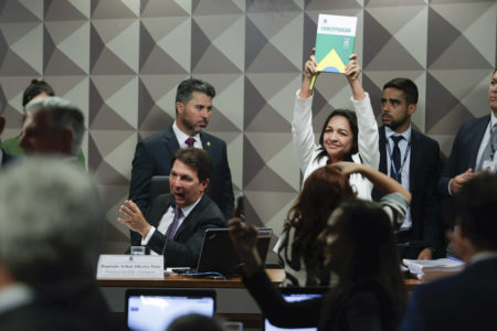 imagem colorida mostra CPMI do 8 de janeiro e senadora eliziane gama levantando constituição federal pgr - Metrópoles