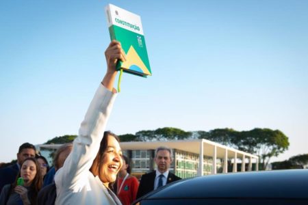 Foto colorida de senadora Eliziane Gama segurando a Constituição Federal na Praça dos Três Poderes - Metrópoles