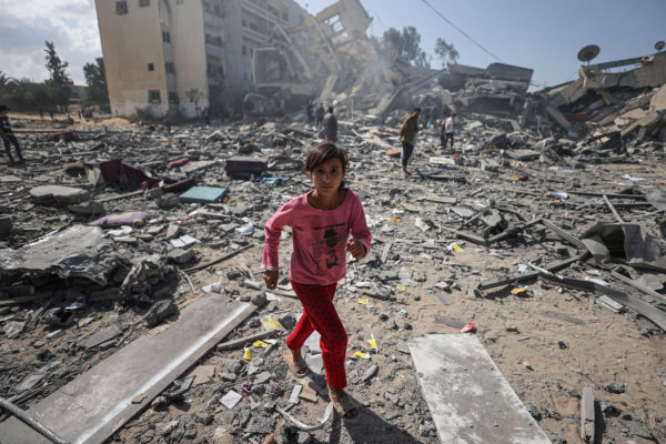 Uma menina caminha entre os escombros de edifícios residenciais após ataques aéreos israelenses no bairro de al-Zahra, na Faixa de Gaza, em 19 de outubro de 2023