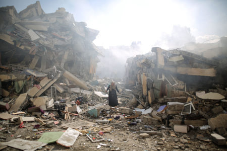 Uma moradora fica chateada ao caminhar perto dos escombros de edifícios residenciais após os ataques aéreos israelenses no bairro de al-Zahra, na Faixa de Gaza