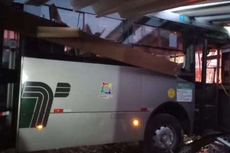 Imagem colorida mostra ônibus dentro de garagem de casa, após colisão - Metrópoles