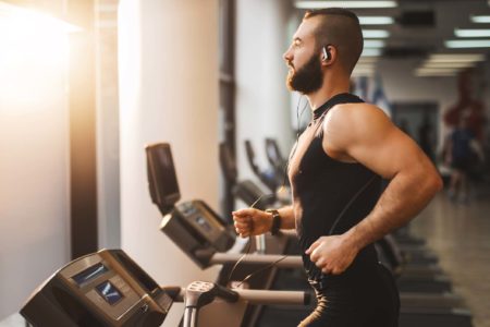 Foto mostra homem musculoso e de barba correndo em esteira