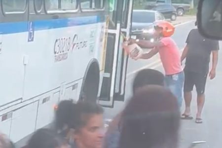 Foto colorida de homem jogando gasolina em ônibus no Rio de Janeiro - Metrópoles