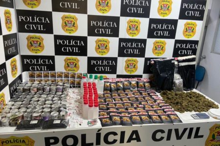 Imagem mostra drogas dispostas sobre mesa com distintivo da Polícia Civil ao fundo - Metrópoles