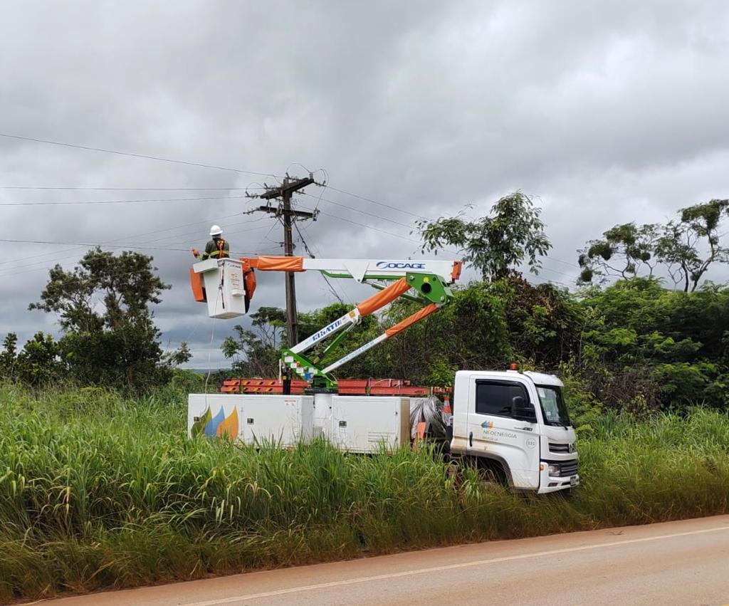 Fotografia colorida mostrando caminhão de empresa de energia com funcionário mexendo em poste-Metrópoles