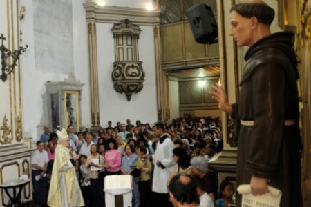 foto colorida com imagem de Frei Galvão dentro da igreja de Frei Galvão, com fiéis ao fundo, em São Paulo - Metrópoles