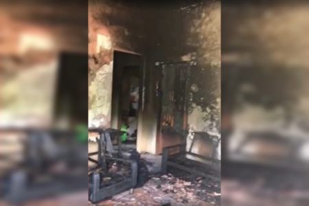 Imagem colorida mostra cômodo de casa totalmente destruído após incêndio, com paredes e móveis quimados, além de fuligem sobre as superfícies