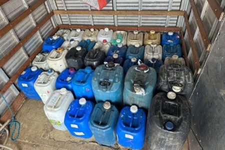 Imagem colorida mostra diversos galões, a maioria na cor azul e alguns na cor branca, que foram apreendidos pela Polícia Civil em uma operação que descobriu uma fábrica de gasolina falsa - Metrópoles
