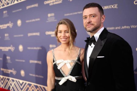 Foto colorida de Justin Timberlake e Jessica Biel em tapete vermelho. Ele usa terno preto, ela, vestido preto com detalhes - Metrópoles