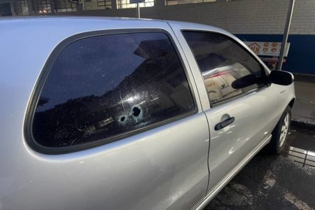 carro prato com duas marcas de tiros na janela traseira