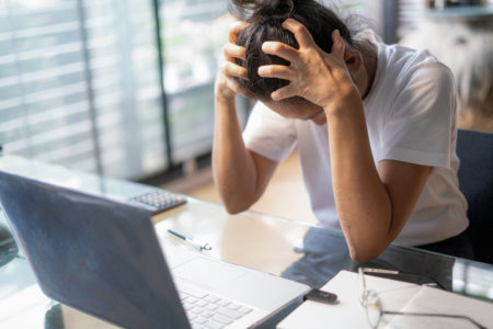 Mulher cansada chorando na mesa de trabalho