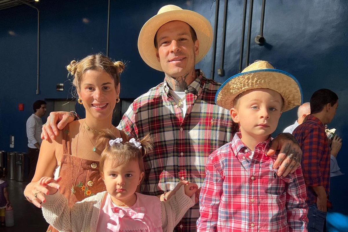 Foto colorida de mulher, homem, menina e menino com roupas de festa junina - Metrópoles