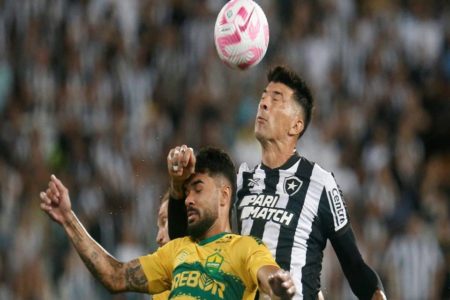 Foto colorida de jogador do Botafogo cabeceando bola com jogador do Cuiabá