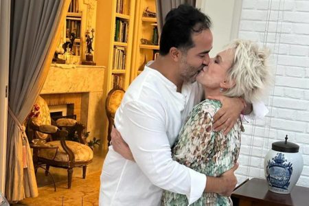 Foto colorida de Ana Maria Braga e Fábio Arruda dando beijão apaixonado - Metrópoles