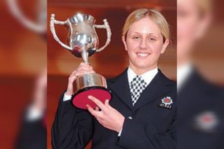 Foto mostra a policial Stacey Rigby com seu uniforme preto e segurando um troféu. Ela descobriu um câncer de intestino por acaso