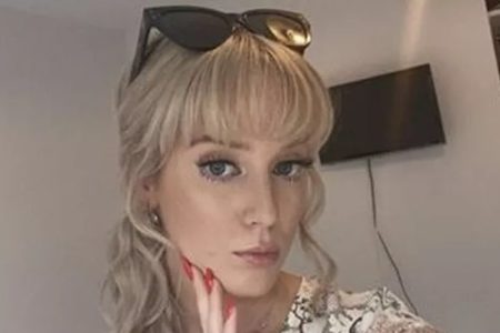 Foto mostra Lucy Younger, uma jovem loira, de franja, com um óculos escuro na cabeça e que teve câncer no cérebro