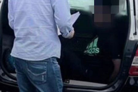 Em foto colorida homem com camiseta preta, na qual há logomarca da Adidas, dentro de carroceria de viatura policial; ele é um professor que foi preso suspeito de estuprar aluna de 9 anos - Metrópoles