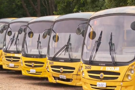 Imagem colorida de ônibus escolares amarelos enfileirados em garagem - Metrópoles