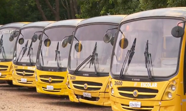 Imagem colorida de ônibus escolares amarelos enfileirados em garagem - Metrópoles