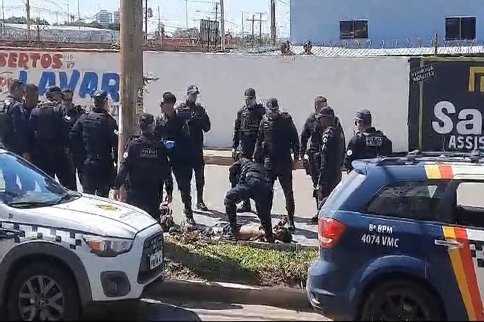 Imagem colorida mostra policiais abordando homem caído ao chão