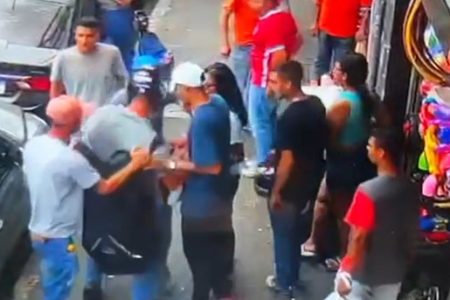 Imagem colorida mostra quadrilha com quatro homens e uma mulher em volta de um motociclista, pegando a mochila do rapaz, que ainda está de capacete; crime ocorreu na rua Barão de Duprat, no centro de São Paulo - Metrópoles