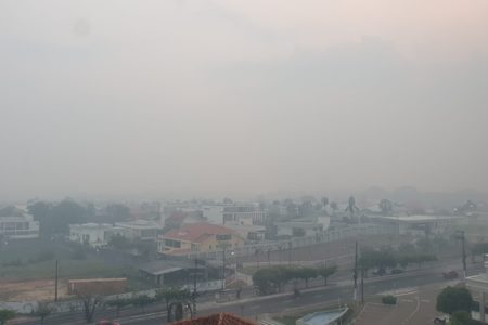 Imagem colorida de paisagem com casas e muita fumaça