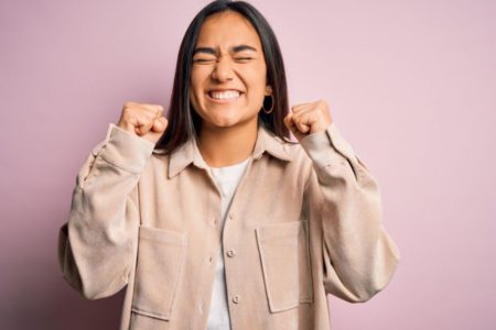 Mulher fazendo gesto de sorte com as mãos para o mês de novembro