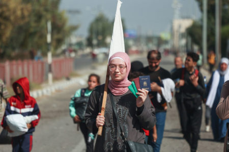 Imagem colorida mostra palestina segurando um passaporte enquanto foge do Norte para o Sul da Faixa de Gaza - Metrópoles