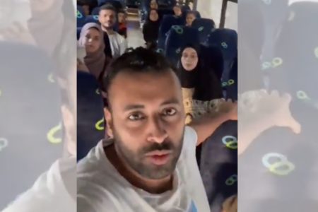 Imagem colorida mostra Hasan Rabee chega ao portão de Rafah com outros brasileiros para sair de Gaza - Metrópoles