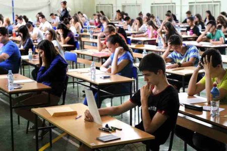 Na foto, alunos fazem prova em uma sala de aula
