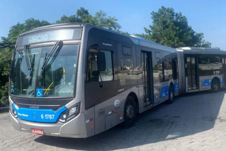 Imagem colorida de ônibus articulado com adesivo azul - Metrópoles