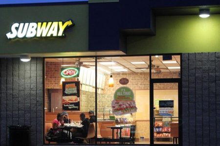 Imagem colorida de uma loja do Subway nos Estados Unidos, com pessoas sentadas à mesa fazendo uma refeição - Metrópoles