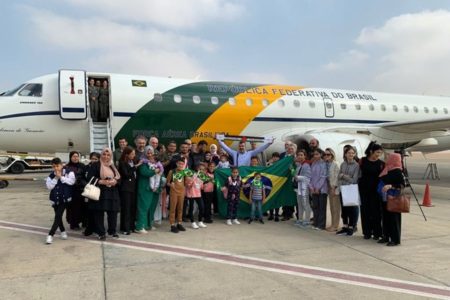 Imagem colorida mostra Brasileiros que estavam na Faixa de Gaza se reúnem em frente ao avião no aeroporto do Cairo - Metrópoles